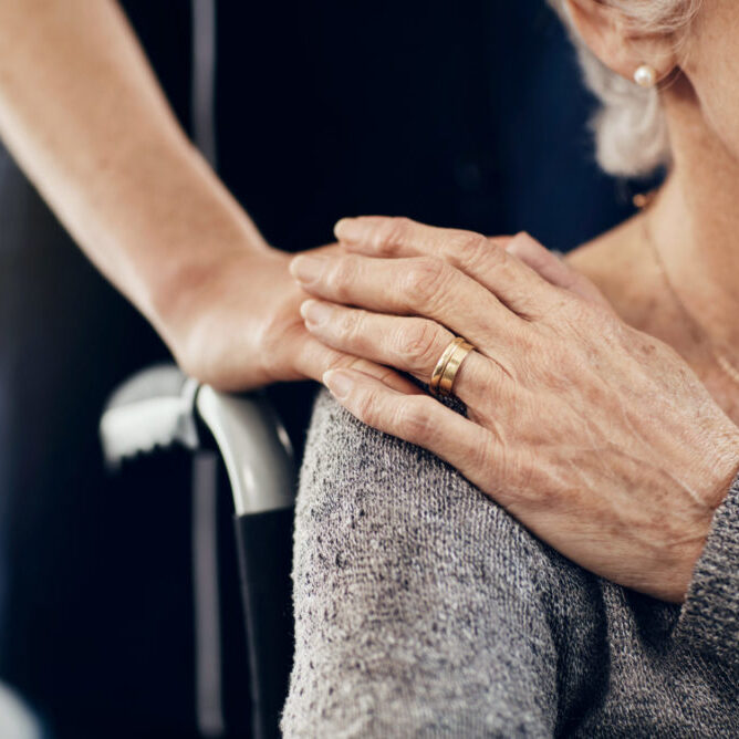 Cropped shot of a female caregiver comforting a senior woman